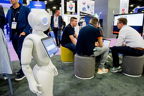 A robot walking past some exhibition visitors